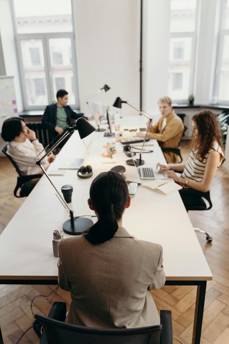 A team reviewing work together at a long desk